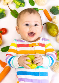 Portrait of cute baby girl playing with toys on table