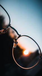 Close-up of light bulb against sky during sunset