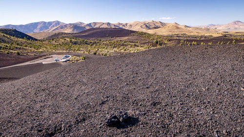 Scenic view of land and mountains against sky