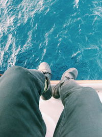 Low section of man relaxing on sea shore