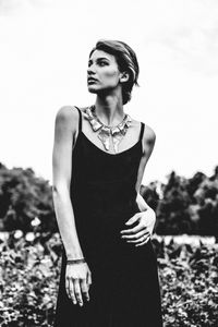 Portrait of young woman standing against sky