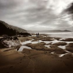 Man standing on beach against sky