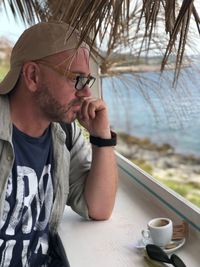 Man looking at sea through window