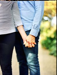 Midsection of couple holding hands