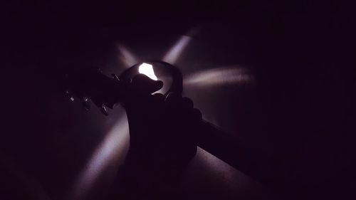 Close-up of hand on illuminated lamp