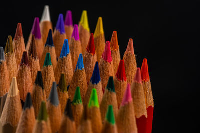 Close-up of colored pencils against black background