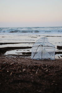 Surface level of beach against sky during sunset