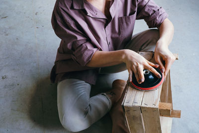 Midsection of woman holding while sitting at home