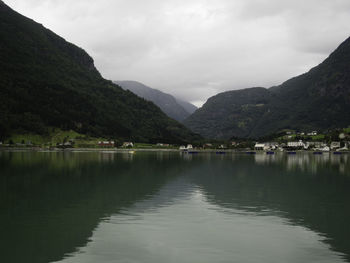 Scenic view of lake by mountains against sky