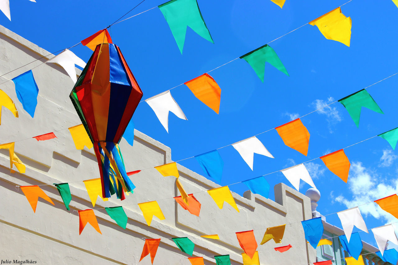 LOW ANGLE VIEW OF COLORFUL FLAGS AGAINST SKY