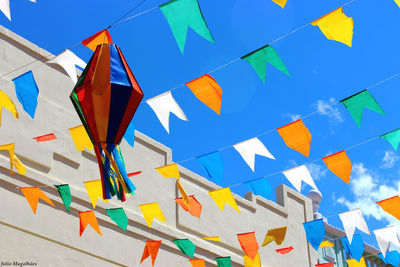 Low angle view of colorful flags against blue sky