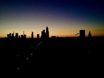 Silhouette cityscape against sky during sunset