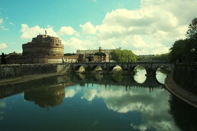 Arch bridge over river against sky