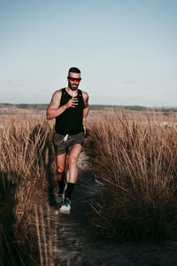 Full length of young man wearing sunglasses against sky