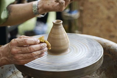 Cropped hands of man making pot