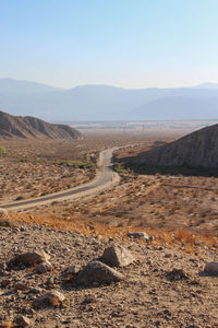 Scenic view of road by mountains against sky