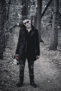 Demon with a chainsaw in the forest on halloween