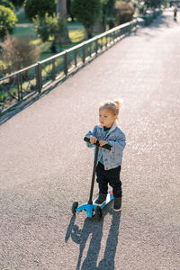 Portrait of boy skateboarding on road