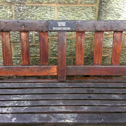 Close-up of wooden bench on fence