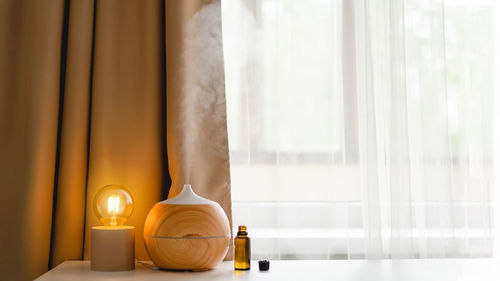 Aromatherapy concept. aroma oil diffuser on the table against the window.