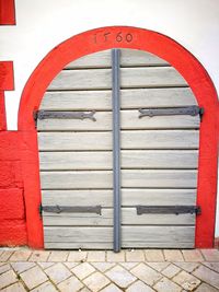 Closed red door with text on wall