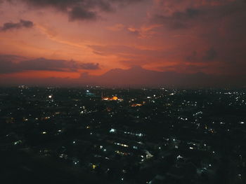 High angle view of illuminated buildings against sky at sunset