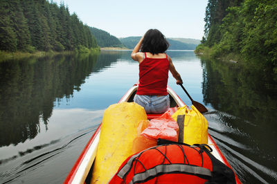 Rear view of woman on lake against sky