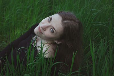 Close up smirking woman in tall grass staring directly into camera portrait picture