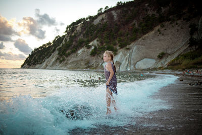 Full length of boy on beach against sky