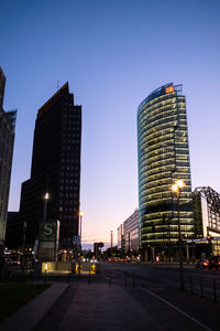 Illuminated buildings against sky at dusk