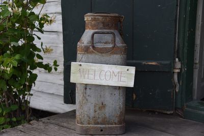 Welcome text on old milk canister against door