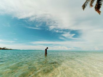 Man standing in sea against sky