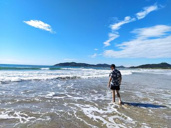 Full length of man standing on beach against sky