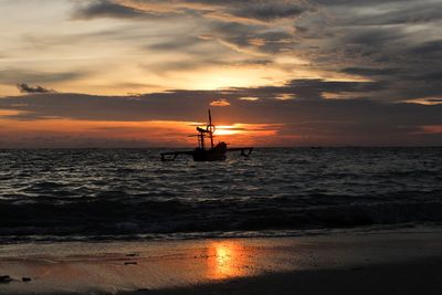 Silhouette boat in sea against sky during sunset