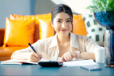 Portrait of young businesswoman working at desk in office