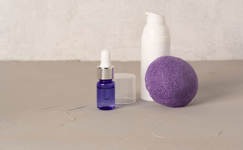 Beauty, spa and wellness concept. facial cosmetic products, konjac sponge on gray  background. 