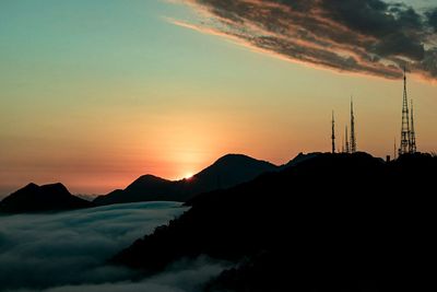 Silhouette of communications tower at sunset