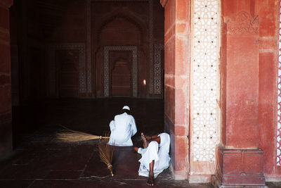Male cleaners with brooms at mosque