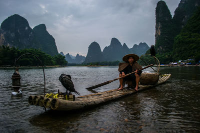 Fisherman paddleboarding in river 