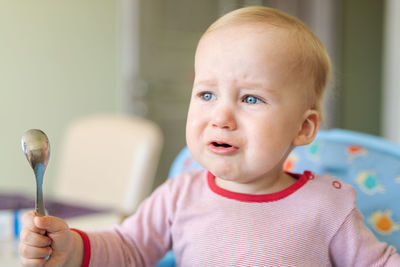 Close-up of cute baby crying at home