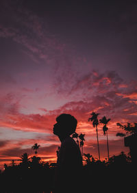 Silhouette man against orange sky