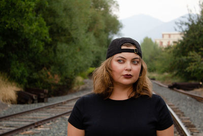 Young woman standing on railroad tracks