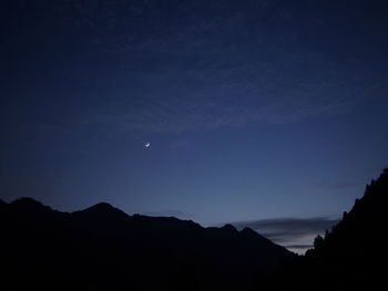 Scenic view of silhouette mountains against sky at night