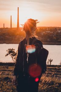 Man drinking water from glass during sunset