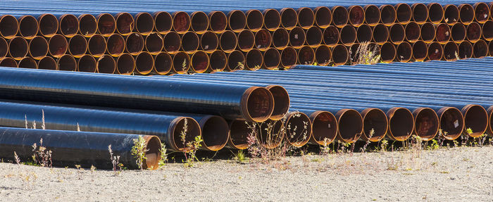 Stack of pipes on field