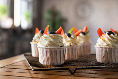 Cupcakes with white icing decorated with berries and mint. delicious dessert. festive bakery.