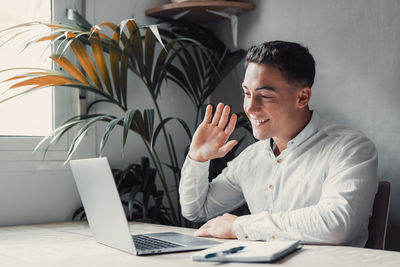 Young man using laptop at table