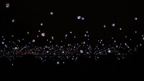 Crowd at music concert against sky at night