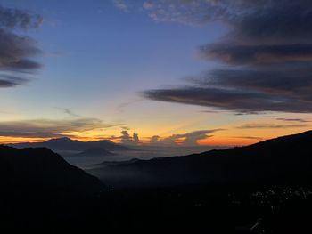 Scenic view of silhouette mountains against sky at sunset