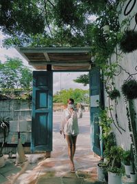 Full length of woman standing against trees